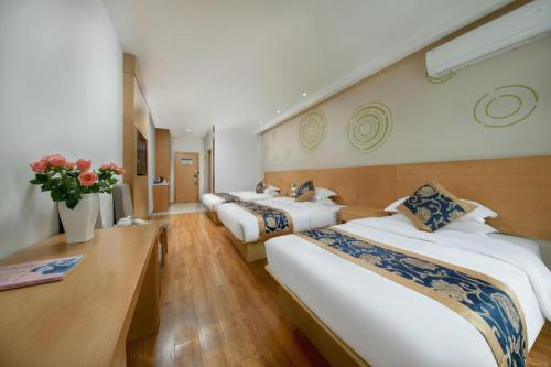 a row of three beds in a room at Green Tree Inn Fengxian New City Metro Station Jiukeshu Art Center in Sanguantang