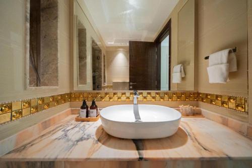 a large bathroom with a tub and a large mirror at GGIVV VACATION HOMES RENTAL 1400 FT 1 BEDROOM LUXURY SERVICE Apartment in Dubai