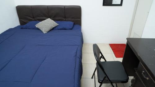 ein Schlafzimmer mit einem blauen Bett und einem Stuhl in der Unterkunft Rumah Penataran Syariah in Blimbing