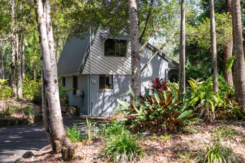 a white house in the middle of trees at Bayshore Bungalow 4 - Oceanstays in Byron Bay
