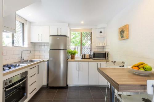 a kitchen with a refrigerator and a bowl of fruit at Bayshore Bungalow 4 - Oceanstays in Byron Bay