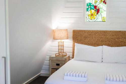 Bayshore Bungalow 4 - Oceanstays في خليج بايرون: غرفة نوم بسرير ومصباح على موقف ليلي