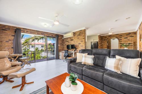 a living room with a couch and a table at Esplanade Charm Apartment in Torquay