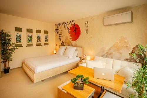 a bedroom with a bed and a desk with a laptop at Zen, Proche Basel, Ambiance Japonaise & Calme in Saint-Louis