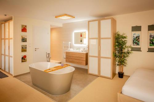 a large bathroom with a tub and a sink at Zen, Proche Basel, Ambiance Japonaise & Calme in Saint-Louis