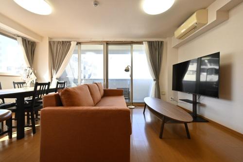 a living room with a couch and a table at コングラッツ湘南 in Fujisawa