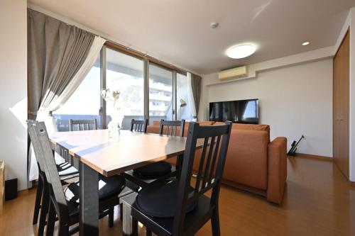 a dining room with a table and chairs and a couch at コングラッツ湘南 in Fujisawa