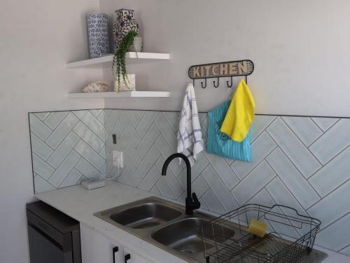 SerenShell House في Stompneusbaai: مطبخ مع حوض وطاولة عمل