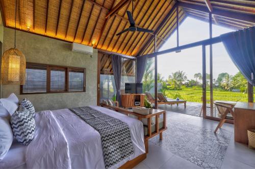een slaapkamer met een bed en een groot raam bij The Udiana Ubud in Ubud