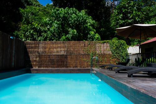 una piscina con due sedie e un ombrellone di Good Mood Resort a Koh Lipe