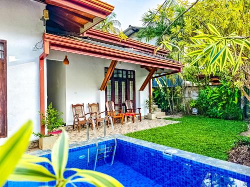 eine Villa mit Swimmingpool und ein Haus in der Unterkunft City Beach Apartment in Bentota