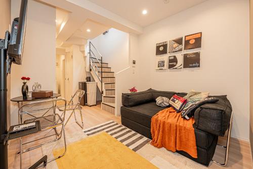 a living room with a black couch and a television at Mi-HOTEL SHIMOKITAZAWA in Tokyo