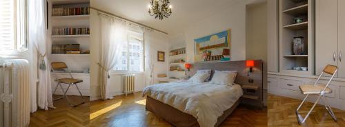 - une chambre avec un lit et deux chaises dans l'établissement LE 50 luxury apartment, à Moulins