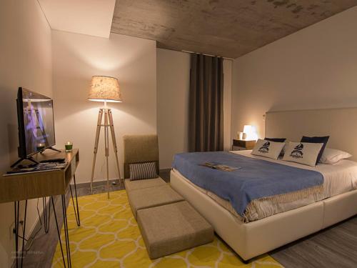 アヴェイロにあるS. Gonçalinho - Suites Apartmentsのベッドルーム(ベッド1台、テレビ、デスク付)