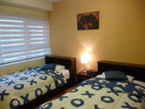 1 dormitorio con 2 camas y ventana en Departamento Quito Histórico, en Quito