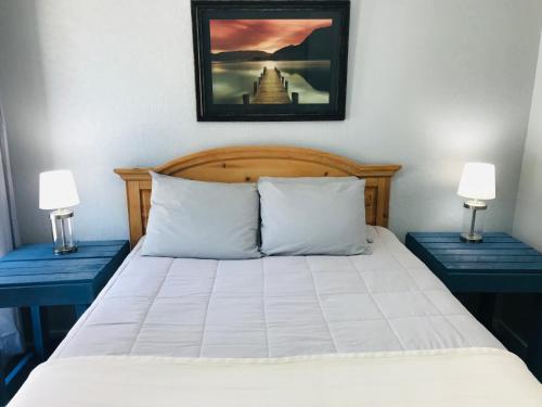 a bedroom with a bed with two blue tables at Lakeland House in Langley