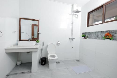 a white bathroom with a sink and a toilet at 2 bedroom in watamu in Watamu