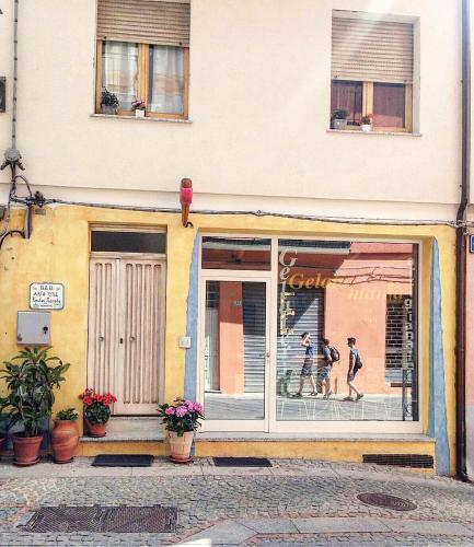two people walking in front of a store window at B&B Aria Ona in Villagrande Strisaili