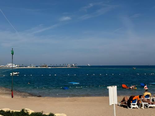 a group of people laying in chairs on the beach at 4 Bedroom Seaside Hurghada Escape in Hurghada