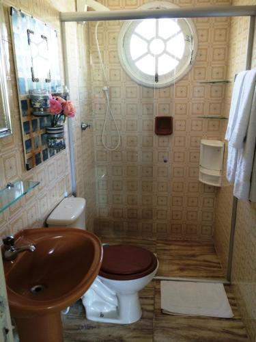 a bathroom with a sink and a toilet and a window at Chalés Villa Bella in Florianópolis