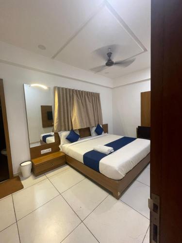 a bedroom with a large bed and a mirror at HOTEL VENUS in Verāval