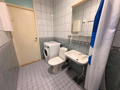 a bathroom with a toilet and a sink at Helsinki Matinkylä Apartment in Espoo