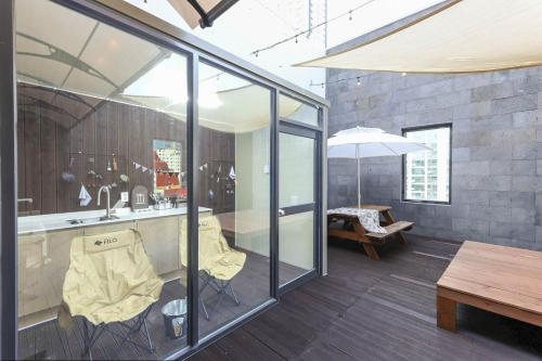 a room with glass walls and a table and an umbrella at Haeundae HaeRium Hotel in Busan