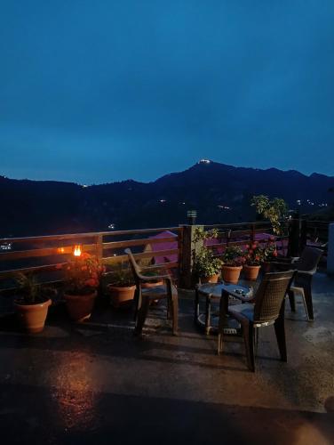 a patio with a table and chairs and potted plants at Mountain and peace in Shimla