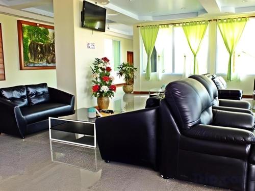 猜也蓬Baan Ingna Resort Hotel的客厅配有黑色皮革家具和玻璃桌