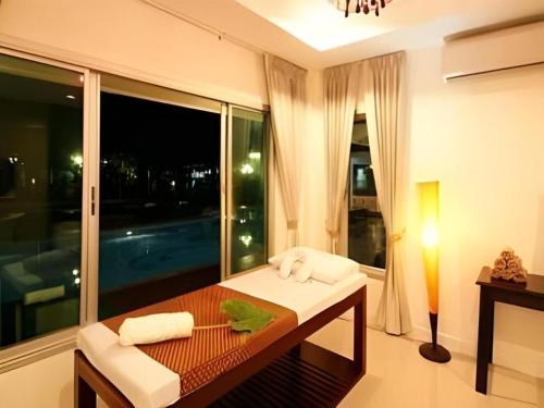 um quarto com uma mesa e uma grande janela em The Forest Home Resort em Ban Dong