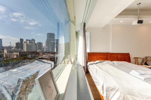 a bedroom with a bed and a view of the city at Fanhua Life IN Nanjing West Road Store 2 in Shanghai