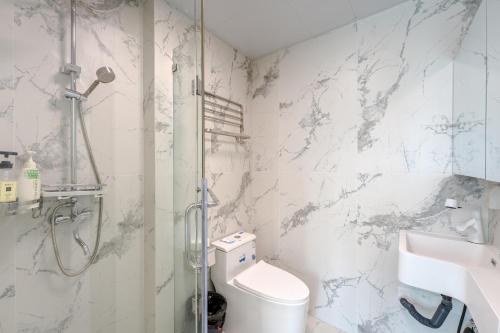 a bathroom with a shower and a toilet and a sink at Fanhua Life IN Nanjing West Road Store 2 in Shanghai