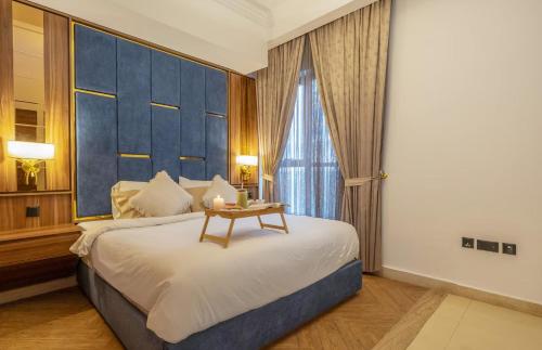 a bedroom with a bed with a blue headboard and a table at GGIVV VACATION HOMES RENTAL 1400 FT 1 BEDROOM LUXURY SERVICE Apartment in Dubai