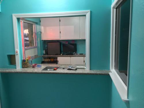 une chambre bleue avec un comptoir et une fenêtre dans l'établissement Walden Motel, à Las Vegas