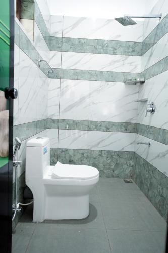 a bathroom with a white toilet in a room at PATHIRAMANAL Service Villas in Alleppey