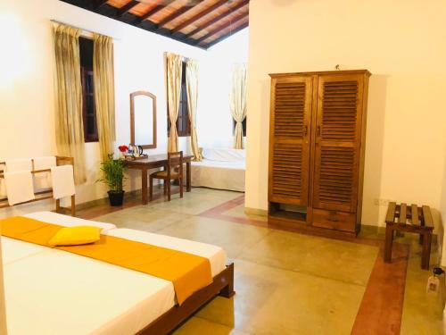 a bedroom with a bed and a desk in a room at Borala Lake Weligama in Weligama