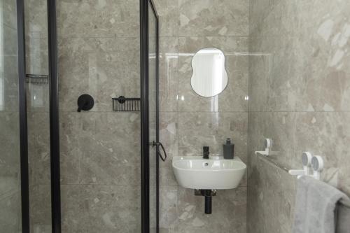 a bathroom with a sink and a glass shower at Nine on Second in Gqeberha