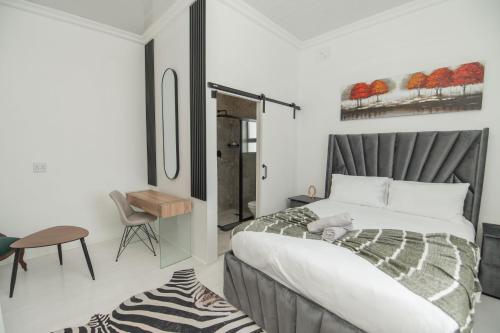 a bedroom with a bed and a table and a chair at Nine on Second in Gqeberha