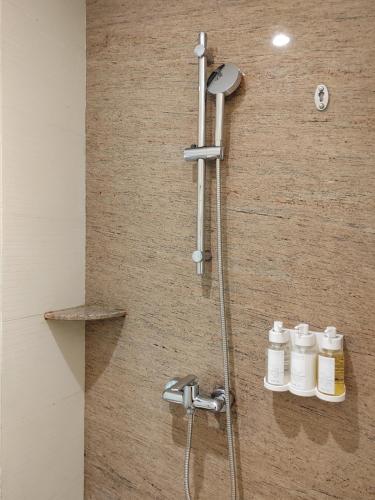 a shower in a bathroom with white jars on a wall at Holiday Inn Nanyang by IHG in Nanyang