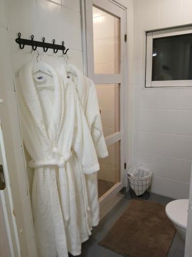 ein Badezimmer mit weißen Handtüchern auf einem Kleiderständer in der Unterkunft Lapland winter cottage in Rovaniemi