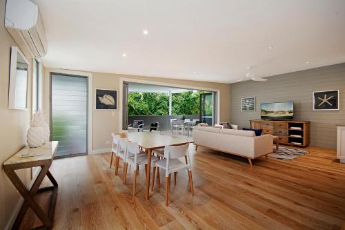 a living room filled with furniture and a table at Jacaranda Noosa in Noosa Heads