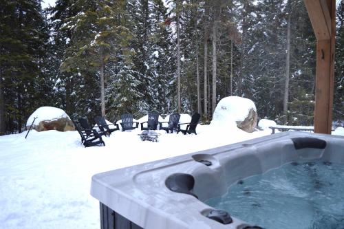 ein Whirlpool mit Stühlen im Schnee in der Unterkunft Spa Foosball Pool table Game Room - Le Kouzy in Sainte-Lucie-de-Doncaster