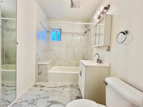 Un baño blanco con inodoro y ducha. en 5bedrooms 3baths 5 beds new renovation 1800sf, en Redwood City