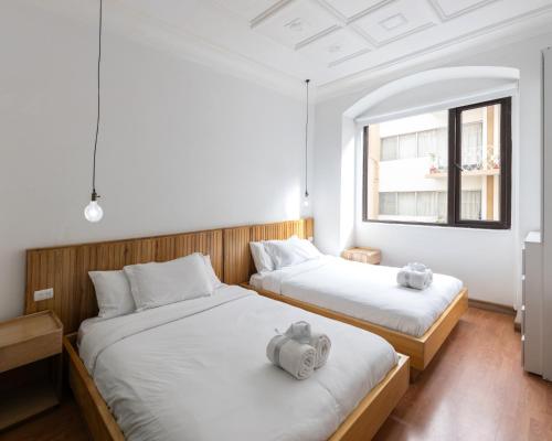 two beds with stuffed animals on them in a room at Lumina Suites in Cuenca