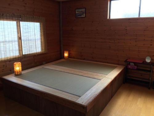 a large bed in a room with two windows at Takayama Ninja House in Takayama