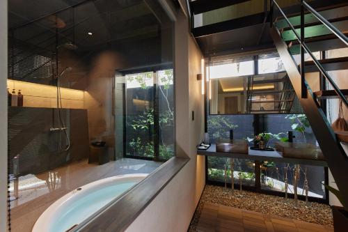 奈良市にあるCocon Nara Sanjyoの浴槽と大きな窓のあるバスルーム
