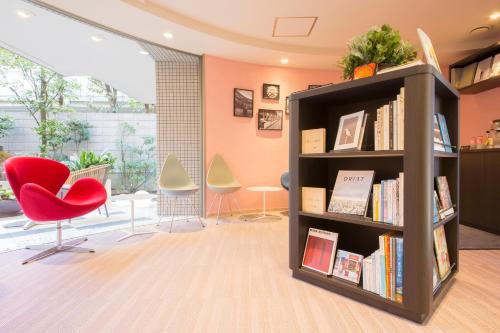 a book shelf with books and a red chair at Tokyu Stay Meguro Yutenji in Tokyo