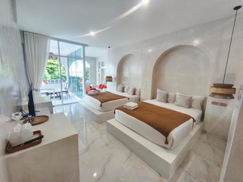 a bedroom with two beds and a living room at Evelia Kohsamed in Ao Phutsa