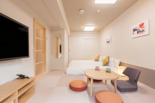 東京にある東急ステイ目黒・祐天寺のベッド、テーブル、テレビが備わる客室です。
