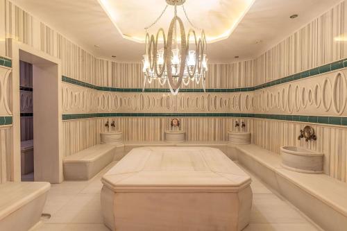 イスタンブールにあるウィンダム グランド イスタンブール カラムシュ マリーナ ホテルのシャンデリアとシンク2つが備わる広い客室です。